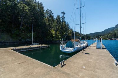 Sailboat moored at a private dock in a sheltered Gulf Islands cove