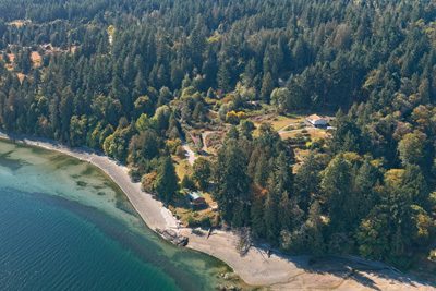 Aerial view of a Salt Spring Island oceanfront beach backed by forest